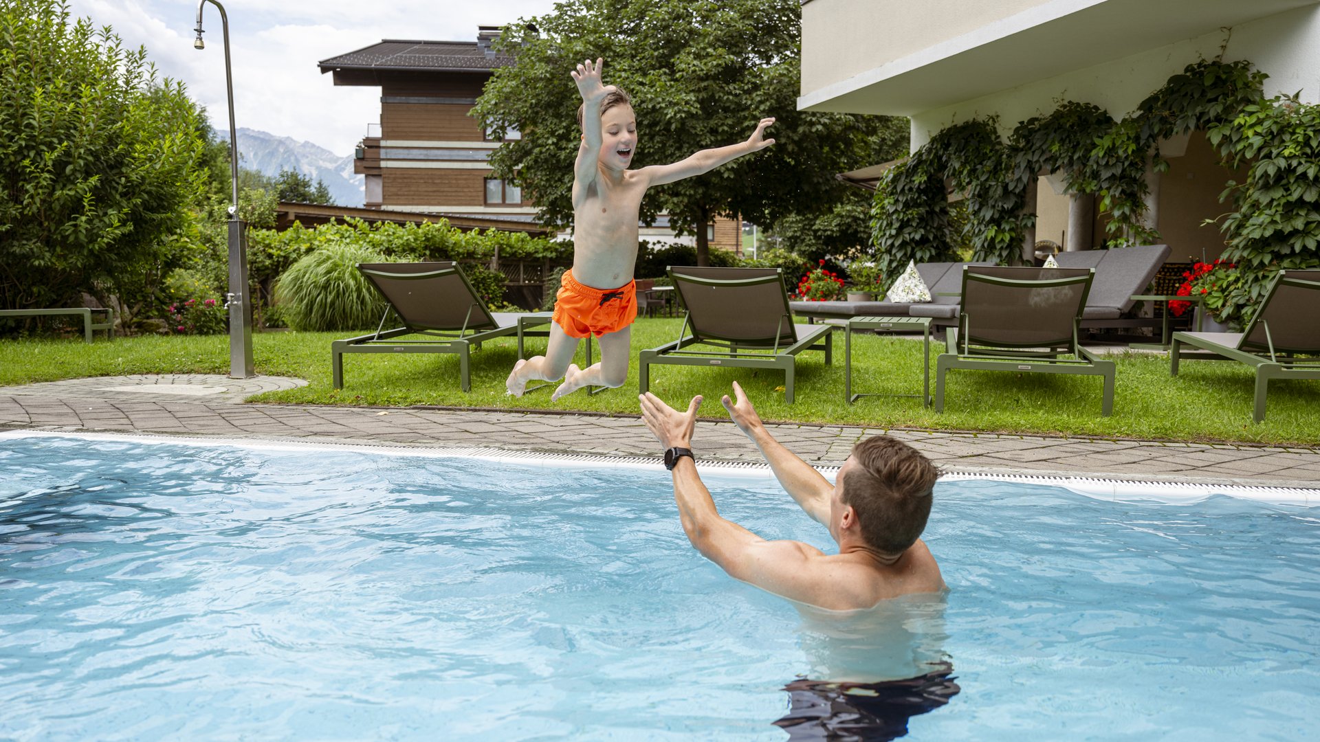 Familienhotel im Salzburger Land: Smaragdhotel Tauernblick Kind springt ins Schwimmbecken, Erwachsener wartet zum Auffangen