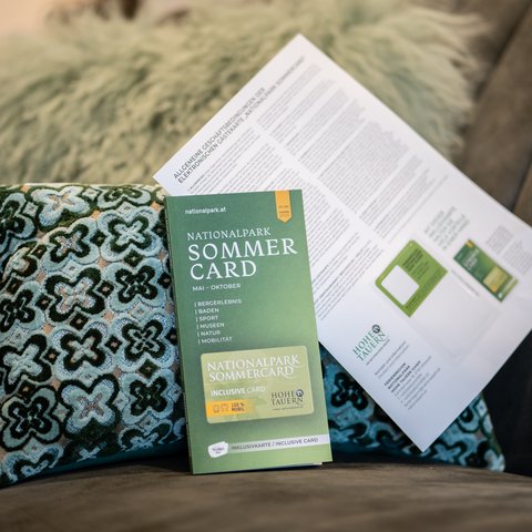 Die besten Hotels im Salzburgerland Nationalpark Sommercard Broschüre und Informationsblatt auf Kissen und Sofa