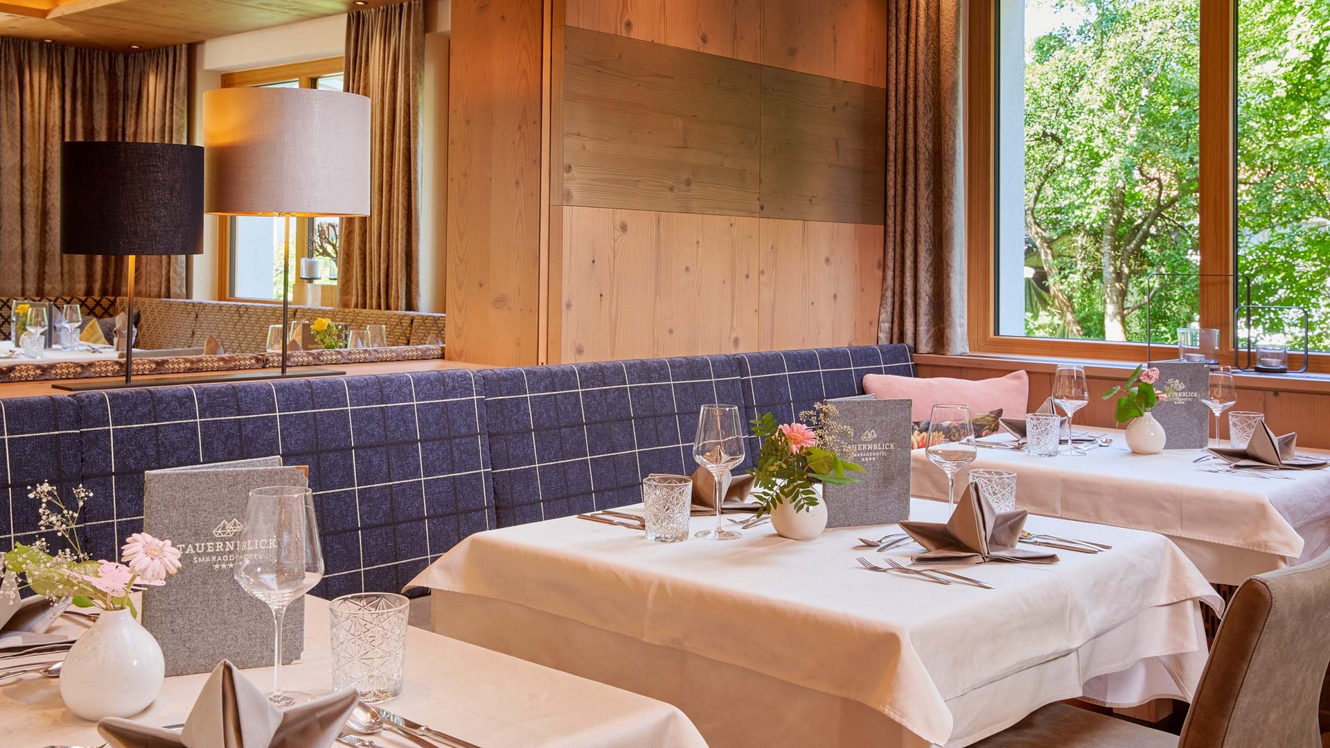 Salzburgerland: hotel jobs Cozy restaurant with set tables and a view of greenery outside the window