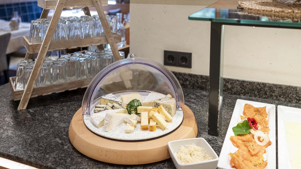 Wellnesshotel Salzburgerland: Smaragdhotel Tauernblick Verschiedene Käsesorten auf Platte neben Lachs und Gläsern auf Holzregal