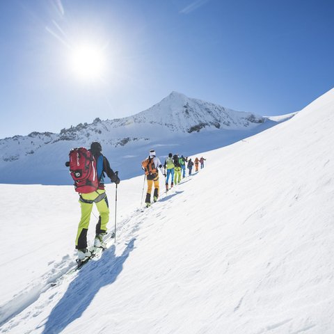 Wanderurlaub in Österreich und mehr Gruppe beim Skitourengehen auf sonnigem verschneitem Bergpanorama
