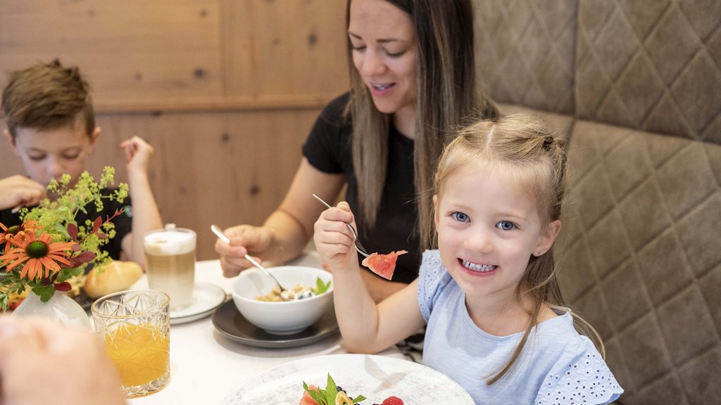 Familienhotel im Salzburger Land: Smaragdhotel Tauernblick Mädchen isst Obst mit Familie im Restaurant