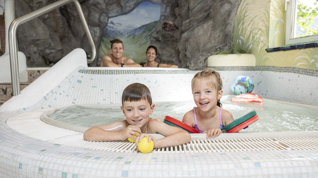 Familienhotel im Salzburger Land: Smaragdhotel Tauernblick Kinder spielen im Hallenbad mit Eltern im Hintergrund
