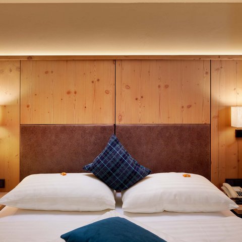 4-Sterne-Hotel Salzburg Umgebung: Preise Gemütliches Hotelzimmer mit Doppelbett, Holzwand und Wandlampen