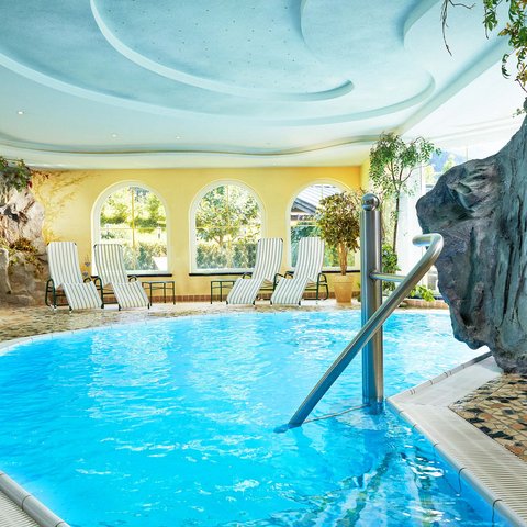 Hohe Tauern National Park: holiday for bikers Bright indoor pool with lounge chairs and rock decoration