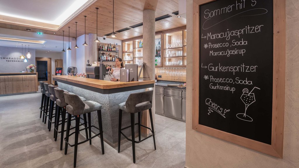 Ihr Pärchenurlaub in Österreich Moderne Hotelbar mit Holzakzenten und Sommer-Getränketafel an der Wand