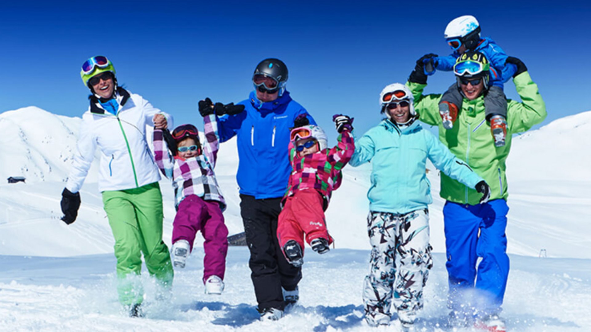 Skiurlaub mit Kindern in Österreich Familie mit Kindern beim Spaß im Schnee in bunter Winterkleidung