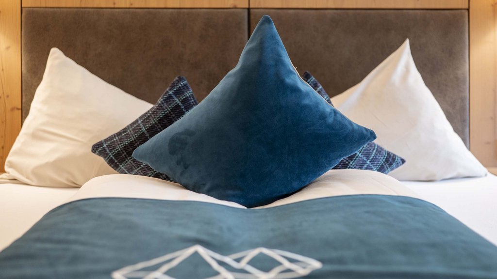 Bramberg am Wildkogel: accommodation Bed with blue and white pillows against wooden paneling