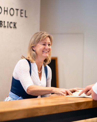 Wildkogel: Hotel mit Blick für das Besondere Rezeptionistin begrüßt Gast im Smaragdhotel Tauernblick
