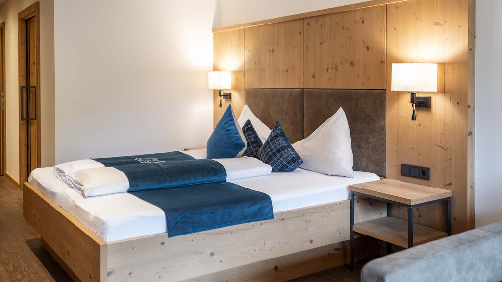 Bramberg am Wildkogel: accommodation Modern bedroom with wooden furniture and blue pillows