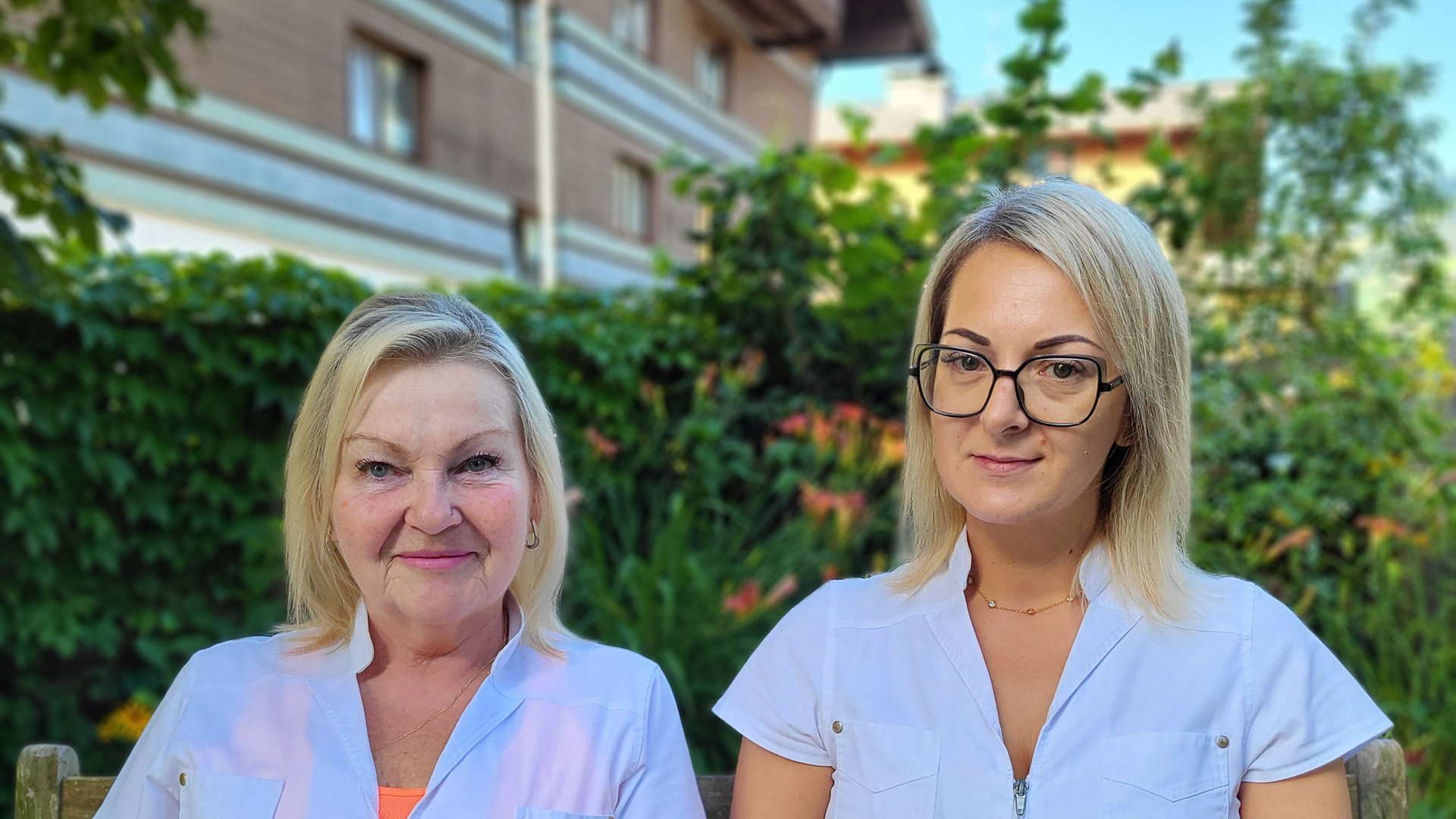 Wildkogel: a hotel with an eye for the extraordinary Two women in white work jackets sitting on a wooden bench in a garden