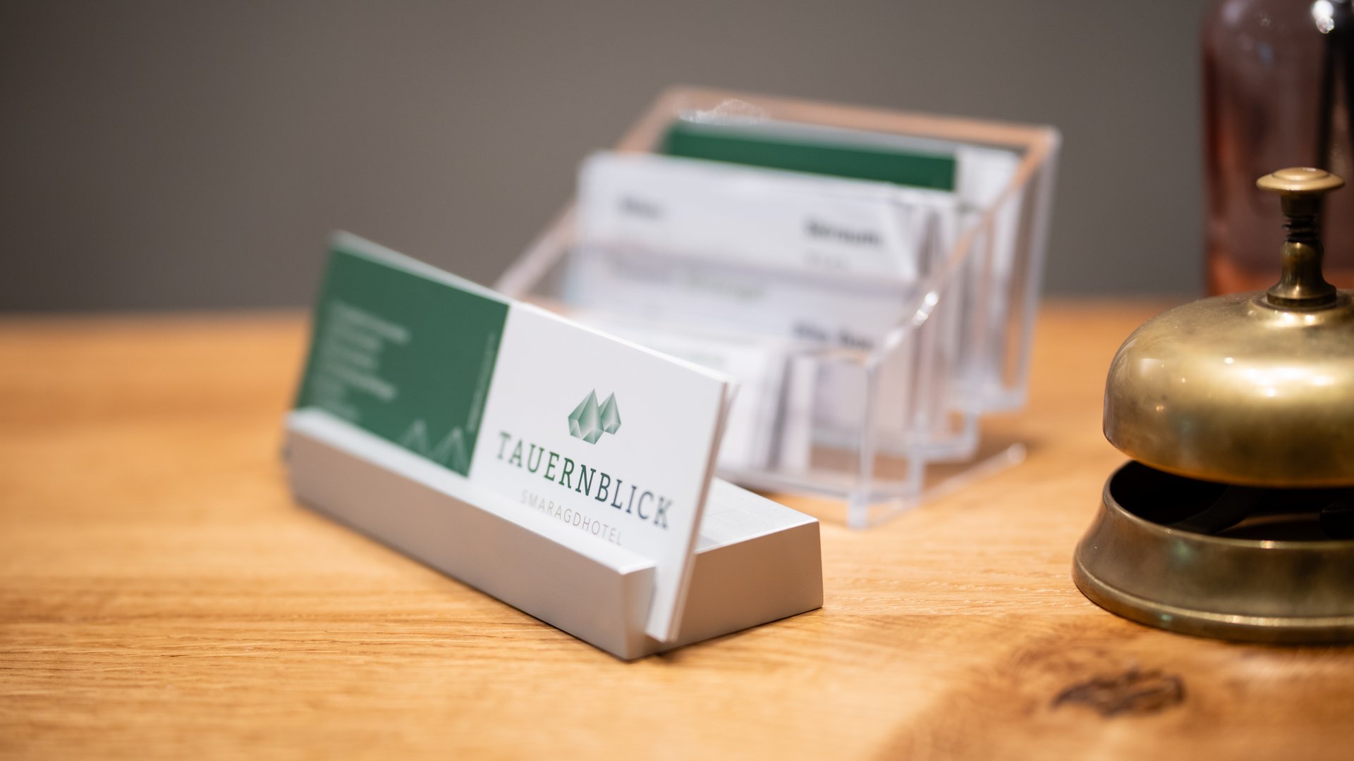 Accommodation near Wildkogel: Smaragdhotel Tauernblick Hotel information card and bell on a wooden counter