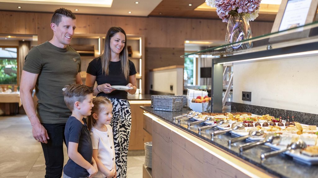 Family hotel in Salzburgerland: 4-star inclusive services Family standing in front of buffet with assorted desserts and treats