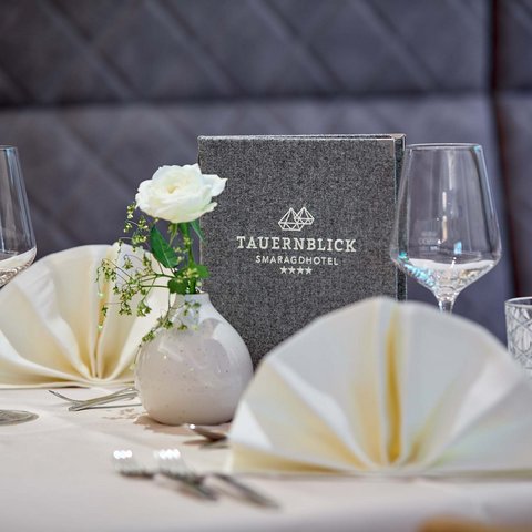 Wellnesshotel Salzburgerland: Smaragdhotel Tauernblick Eleganter gedeckter Tisch mit Menü und Blumendekoration im Hotel Tauernblick