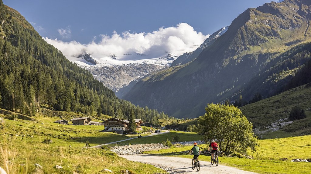 Nationalpark Hohe Tauern: Urlaub für Biker Zwei Radfahrer fahren auf einem Bergweg in einem Tal mit schneebedeckten Gipfeln
