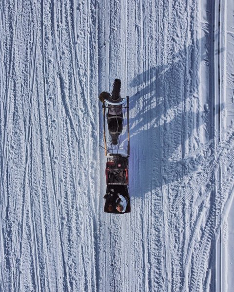 Salzburgerland: Winter im Smaragdhotel Tauernblick Vogelperspektive eines Pferdes, das einen Schlitten durch den Schnee zieht
