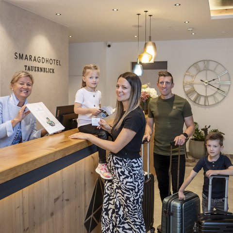 Hotel in Bramberg: Smaragdhotel Tauernblick Familie checkt am Empfang des Smaragdhotel Tauernblick ein