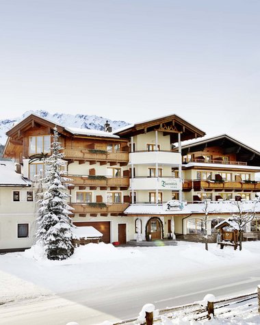 Wildkogel: a hotel with an eye for the extraordinary Hotel in snowy mountain landscape with pine trees and clear sky
