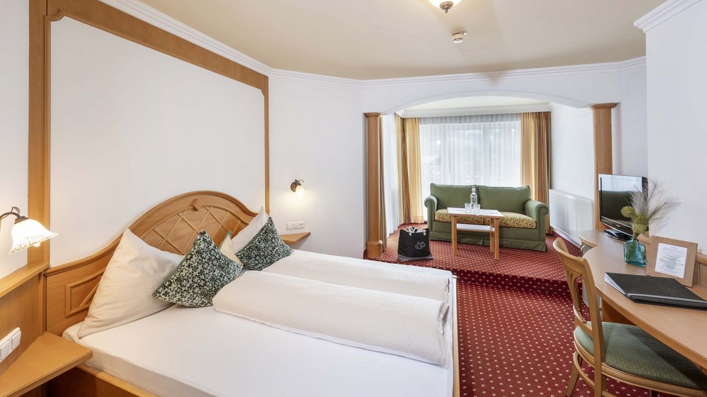 Bramberg am Wildkogel: accommodation Bright hotel room with two single beds, sofa, and television