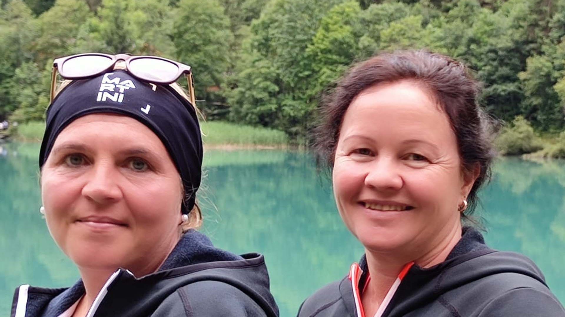 Wildkogel: Hotel mit Blick für das Besondere Zwei Frauen in Outdoorjacken vor einem See und Wald im Hintergrund