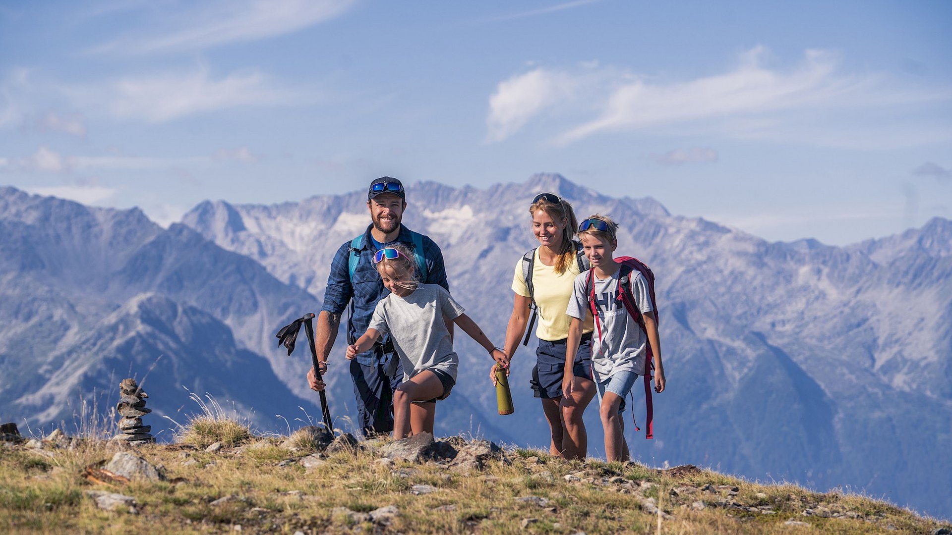 Einmaliges Wanderhotel im Salzburgerland Familie mit zwei Kindern wandert in den Bergen bei sonnigem Wetter