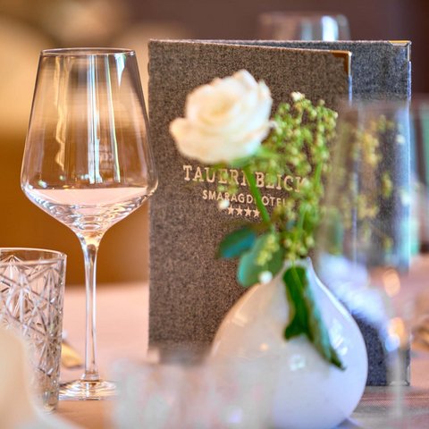 Ihr Pärchenurlaub in Österreich Eleganter gedeckter Tisch mit Weinglas, Wasserglas, Serviette und Blumendekoration
