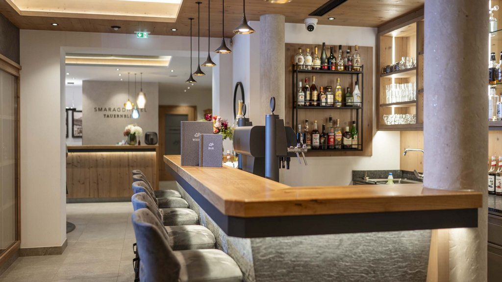 Salzburgerland: wellness hotel with 4 stars and cuisine Modern hotel bar area with wooden counter and illuminated shelves