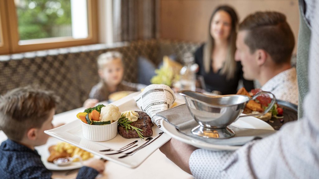 Salzburgerland: wellness hotel with 4 stars and cuisine Waiter serving food to family in a restaurant