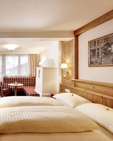 Wildkogel: a hotel with an eye for the extraordinary Cozy hotel room with double bed, sitting area, and skiing pictures on the walls