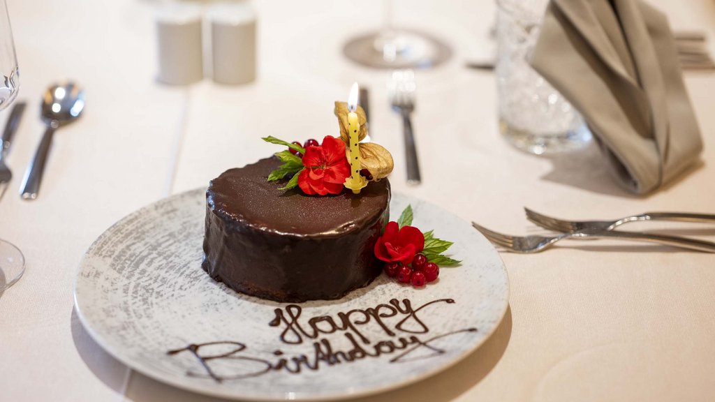 Salzburgerland: wellness hotel with 4 stars and cuisine Chocolate birthday cake decorated with candle and red flowers