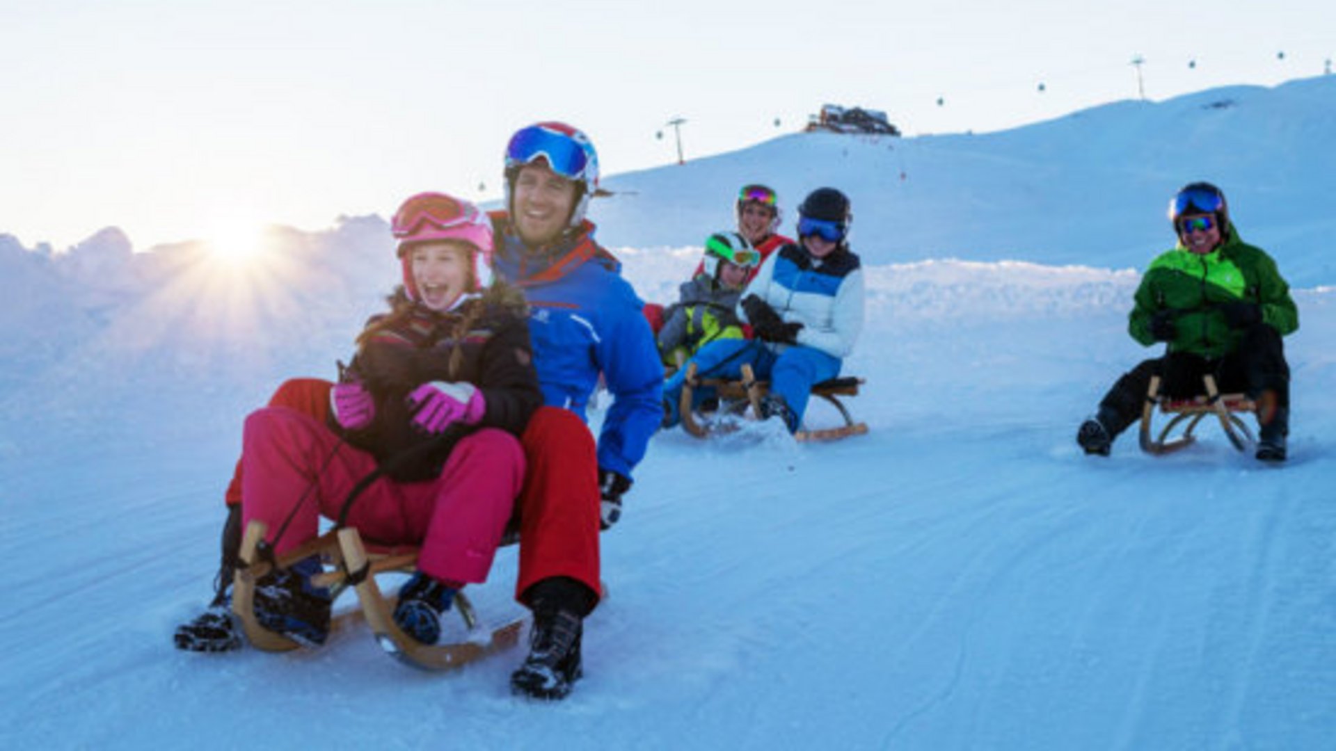 Skiing holidays in Salzburgerland: Smaragdhotel Tauernblick Family sledding on snow on a sunny winter day
