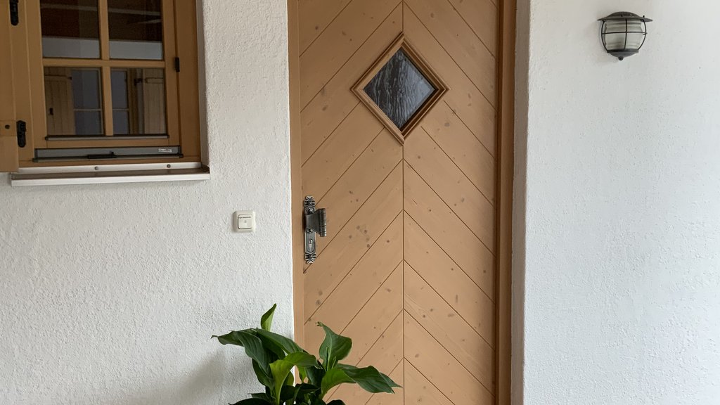 Das Ferienhaus Smaragd: ein wahres Juwel Holztür mit Fenster, Blumentopf und Willkommensmatte vor Hauseingang